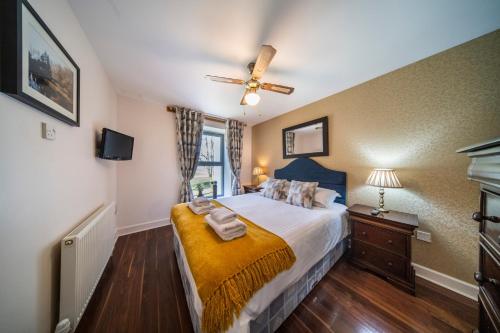 フォート・オーガスタスにあるRaven Wing Apartments - Highland Club Scotlandのベッドと天井扇風機のある寝室