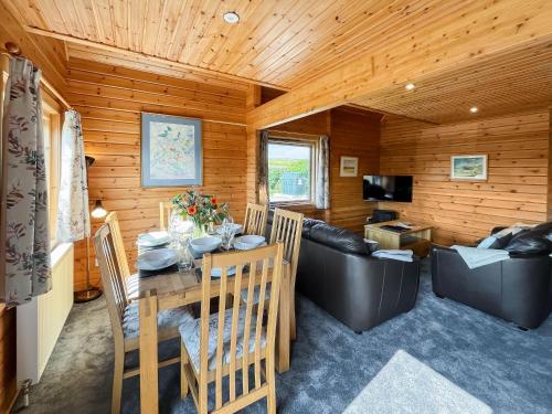a dining room and living room with a table and a couch at Bengairn in Ringford
