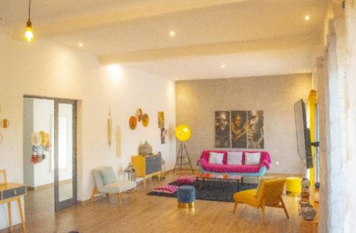 a living room with colorful chairs and a couch at Elysee in Mbour
