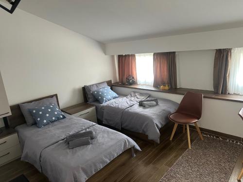 a room with two beds and a chair in it at VP Apartments Bitola in Bitola