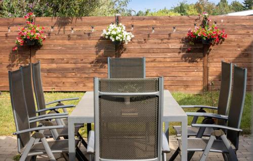 a table and chairs with flowers on a fence at Amazing Home In Føllenslev With Wifi in Føllenslev