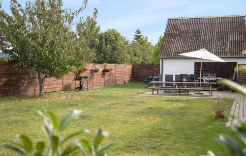 a backyard with a picnic table and a fence at Amazing Home In Føllenslev With Wifi in Føllenslev