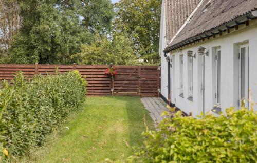 a fence next to a house with a flower pot on it at Amazing Home In Føllenslev With Wifi in Føllenslev
