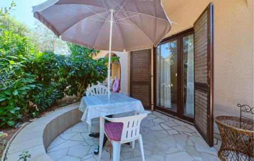 a table and chairs with an umbrella on a patio at 3 Bedroom Pet Friendly Apartment In Artatore in Cunski