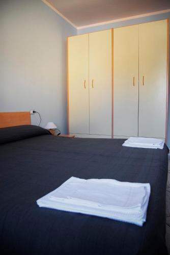 a bedroom with a bed with white sheets and cabinets at Agriturismo il filo di Arianna in Coppito