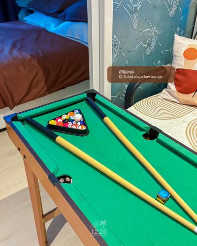 a pool table with two cue sticks in a room at 1226 Azure Staycation in Manila
