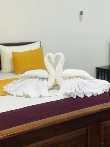 a bed with two swans made out of towels at TESHI SAFARI VILLA in Udawalawe