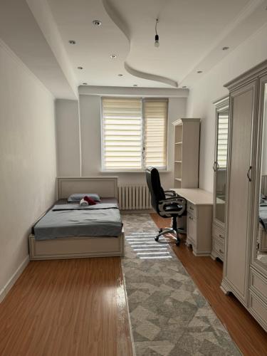 a bedroom with a bed and a desk and a chair at Жетысу-2, 2 А in Almaty