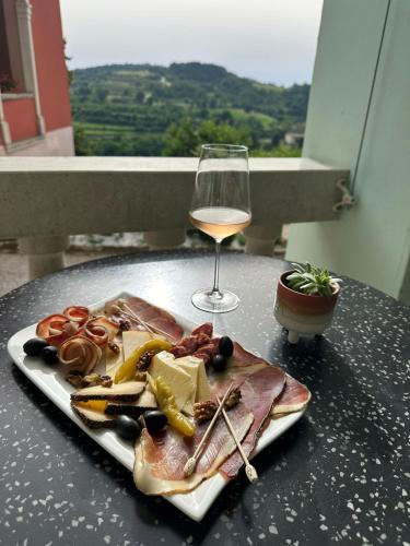 a plate of food and a glass of wine on a table at B&B Mila in Oprtalj