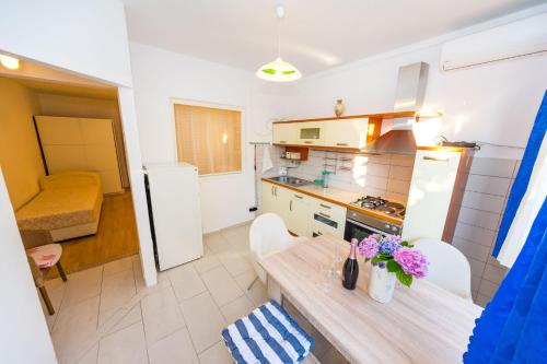 a small kitchen with a wooden table and a dining room at Apartments Borik in Zadar