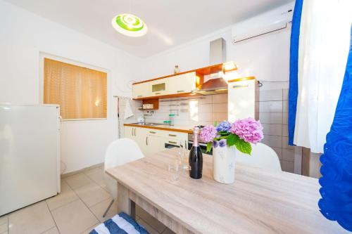 a kitchen with a table with flowers in a vase at Apartments Borik in Zadar