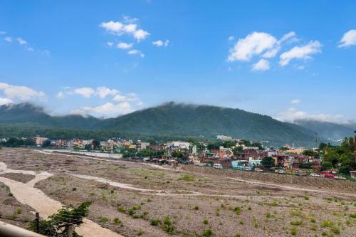 a view of a city with a mountain in the background at Hotel O Dharohar in Rishīkesh