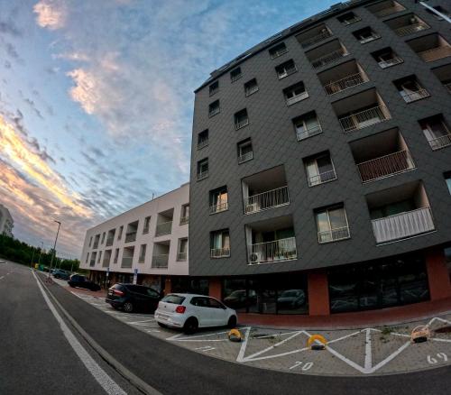 a building with cars parked in a parking lot at SkyFlat Bratislava-New Apartment near Airport Free Parking in Bratislava