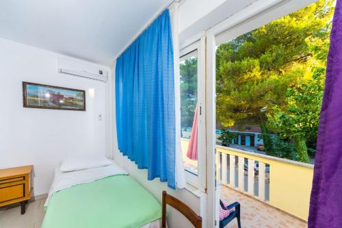 a bedroom with a bed and a large window at Apartments Borik in Zadar