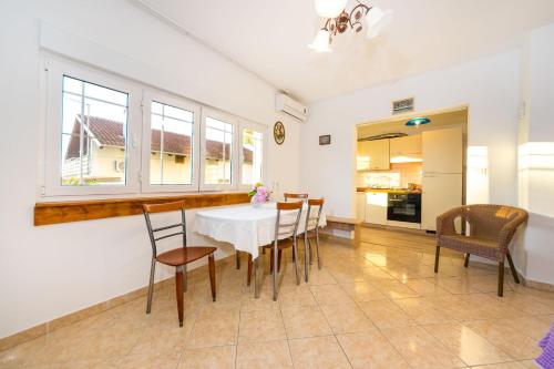 a dining room with a white table and chairs at Apartments Borik in Zadar