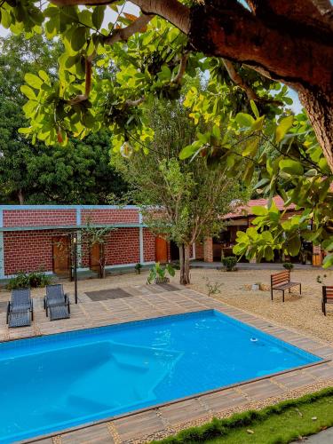 a blue swimming pool in front of a building at POUSADA MARTINS in Carolina