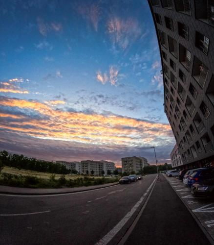 a road with cars parked on the side of a building at SkyFlat Bratislava-New Apartment near Airport Free Parking in Bratislava
