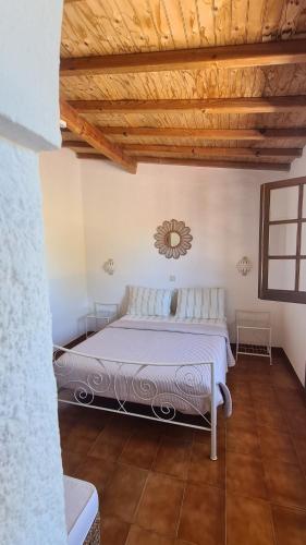 a bed in a room with a wooden ceiling at RÉSIDENCE LES ARCADES in Almádena