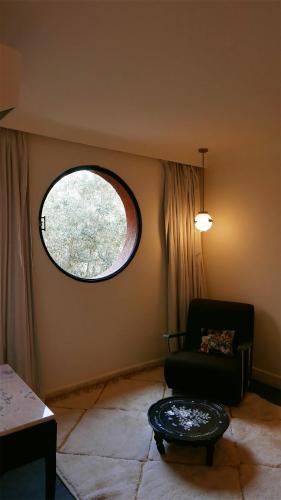 a living room with a chair and a window at MORO Marrakech Boutique Hôtel in Marrakech