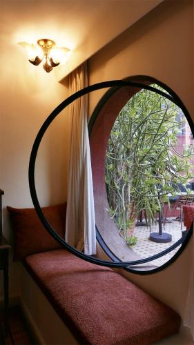 a round mirror on a wall with a window at MORO Marrakech Boutique Hôtel in Marrakech