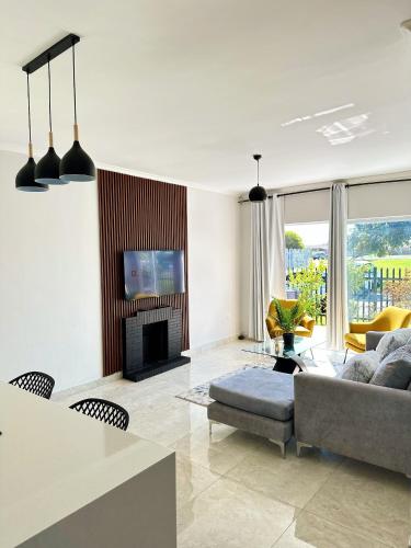 a living room with a couch and a fireplace at Lux Sleek City Haven in Cape Town