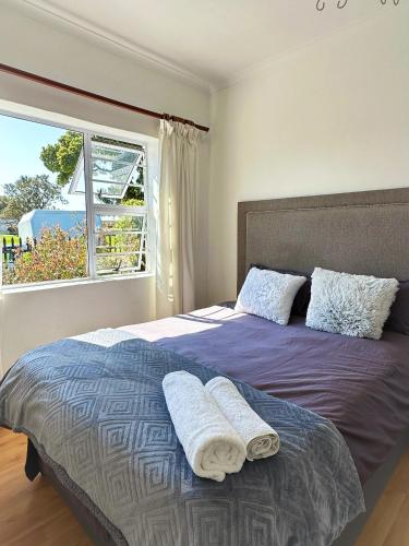 a bedroom with a bed with two towels on it at Lux Sleek City Haven in Cape Town
