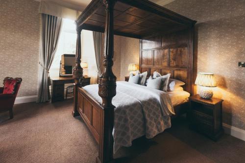 a bedroom with a large bed with a wooden canopy at Rowton Castle in Shrewsbury