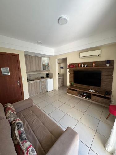 a living room with a couch and a flat screen tv at Apartamento aldeia das águas in Barra do Piraí