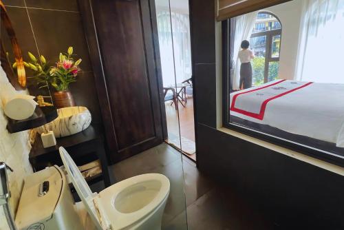 a bathroom with a sink and a toilet and a bed at Sapa Villa Florence in Sa Pa