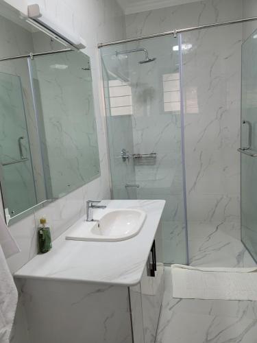 a bathroom with a sink and a glass shower at Mysore House - Nanyuki in Nanyuki