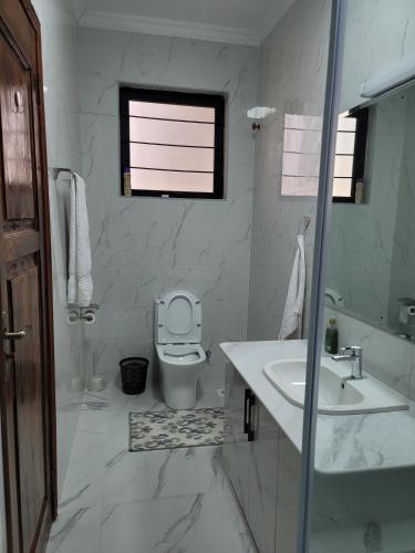 a white bathroom with a toilet and a sink at Mysore House - Nanyuki in Nanyuki