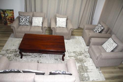 a living room with couches and a coffee table at Mysore House - Nanyuki in Nanyuki
