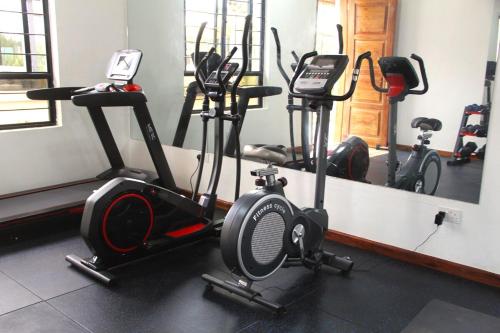 a gym with several exercise bikes and a mirror at Mysore House - Nanyuki in Nanyuki