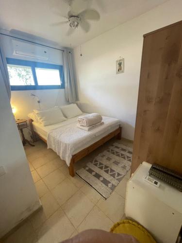 a small bedroom with a bed and a window at אירוח בעמק in Yesod Hamaala