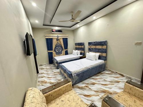 a room with two beds and a tv in it at Sweet Villa Guest House Islamabad in Islamabad