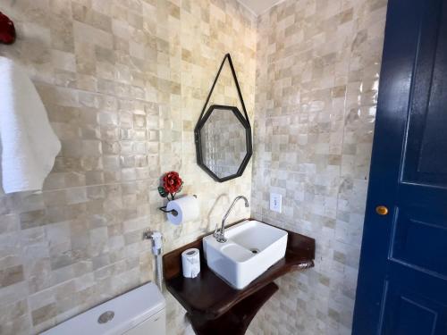 a bathroom with a sink and a mirror and a tub at Pousada Raio de Sol in Lençóis