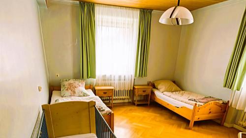 a small room with two beds and a window at Ferienwohnung 1 mit Garten in Crailsheim