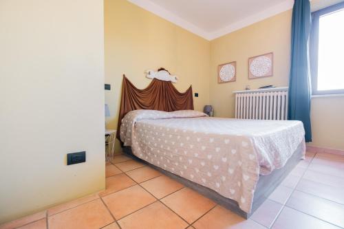 a bedroom with a bed and a window at Palazzetto del Pittore in San Quirico d'Orcia in San Quirico dʼOrcia