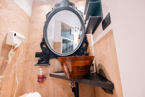 a mirror on a shelf in a bathroom at Palazzetto del Pittore in San Quirico d'Orcia in San Quirico dʼOrcia