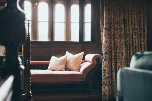 a couch with pillows in a room with a window at Rowton Castle in Shrewsbury