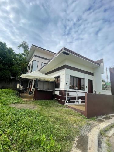 a white house with a lawn in front of it at Richviel Transient House Lucena City Unit1 in Lucena
