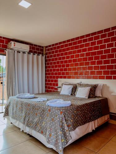 a bedroom with a large bed with a brick wall at POUSADA MARTINS in Carolina
