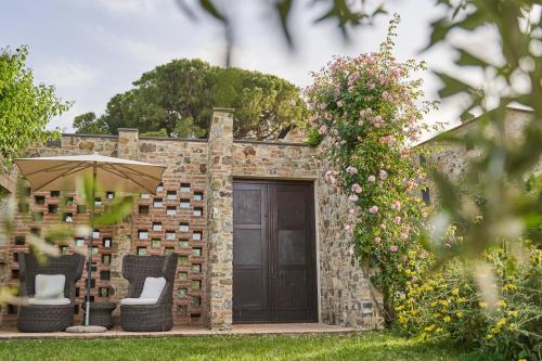 a brick building with two chairs and an umbrella at Poggio Piglia in Chiusi
