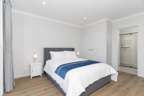 a white bedroom with a large bed and a window at Haven Lakeside Berwick in Berwick