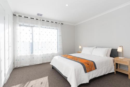a white bedroom with a bed and a window at Haven Lakeside Berwick in Berwick