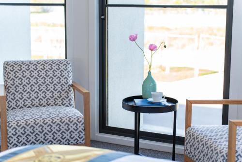 a room with a chair and a vase with a flower on a table at Haven Lakeside Berwick in Berwick