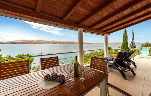 a deck with a table with wine glasses and a view of the water at Nice Apartment In Karlobag With Wifi in Karlobag