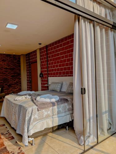 a bedroom with a bed and a brick wall at POUSADA MARTINS in Carolina