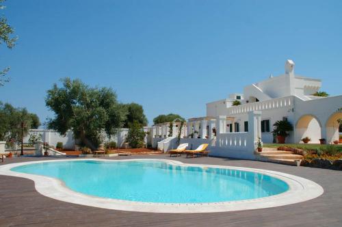 a swimming pool in front of a house at B&B Lamascopone in Fasano