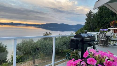 a grill on a balcony with a view of the water at Beachbreeze Panoramic Oceanview 4BR 3BA Romantic Sunrise & Celestial Views in Mill Bay